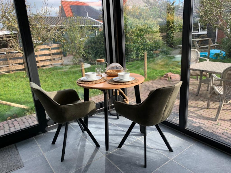 De eethoek bij het raam met zicht op het terras