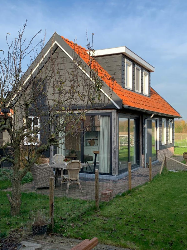 Het houten vakantiehuis Achter de Menne met oranje pannendak in Aagtekerke